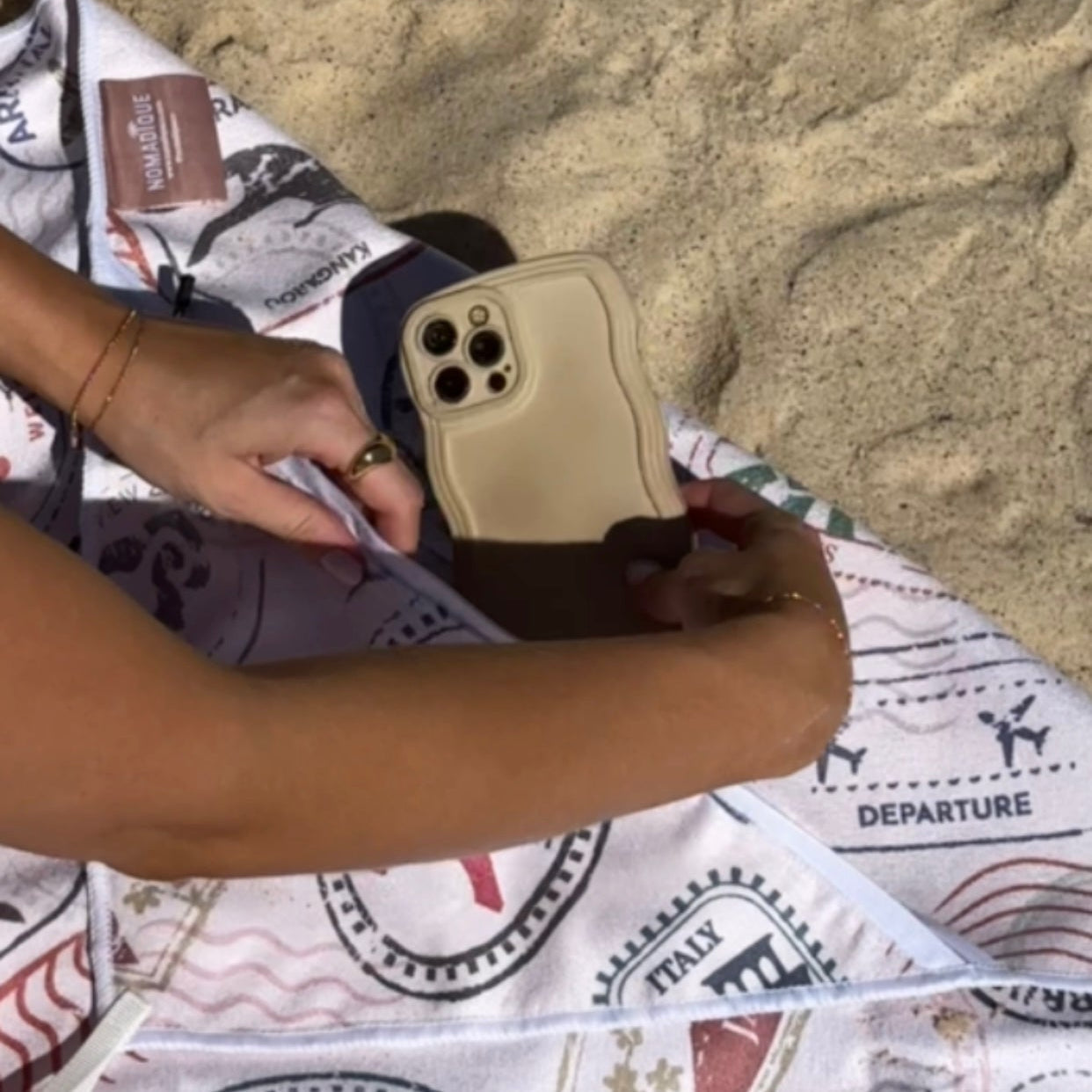 Beach towel with zip pocket — Nomadique Voyager passport-stamp sand-free beach towel with water-resistant zip pocket