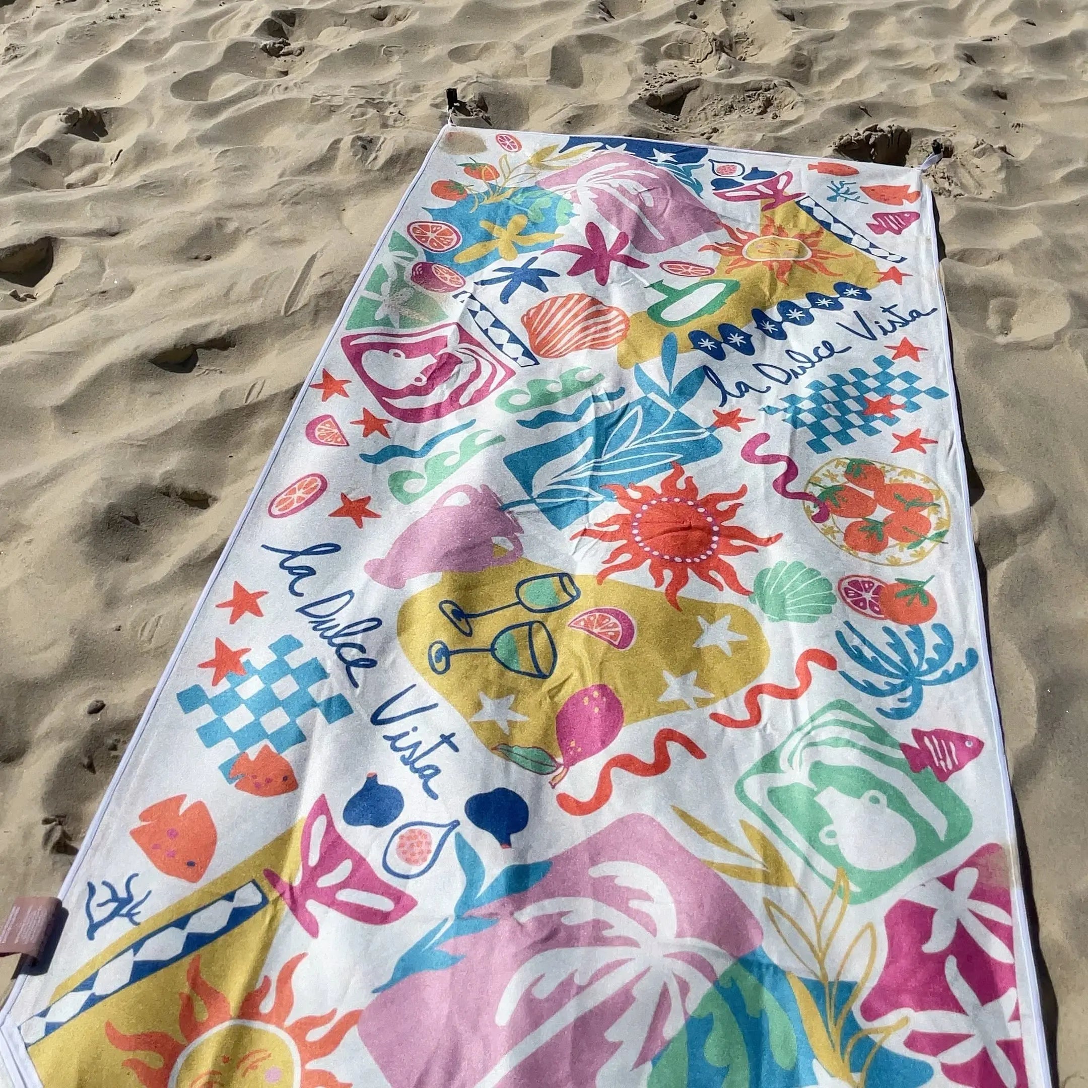 The vibrant overall design and colour harmony of this towel conveys a laid-back, summery atmosphere centered on leisure by the sand.