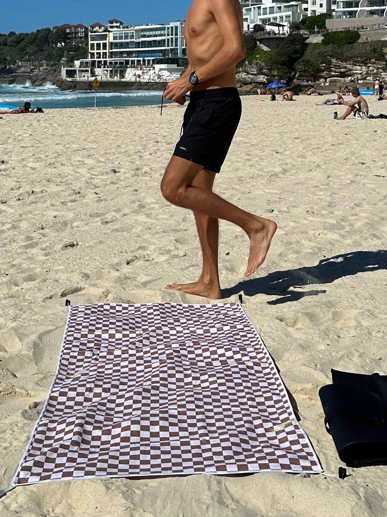 A geometric sand free beach towel laid in the sand