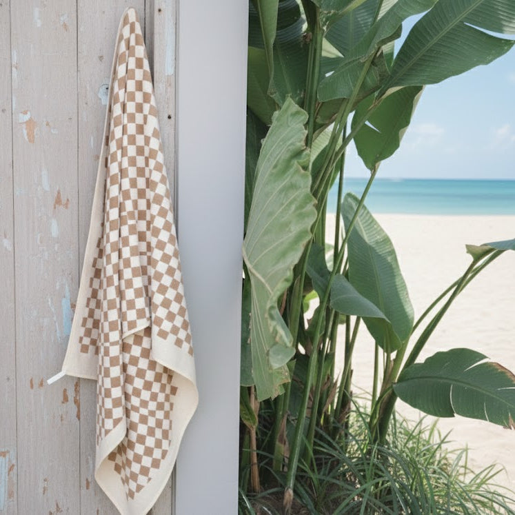 Marrakesh Sand Free Beach Towel With Pocket hanging in a wooden wall whicj gives a modern feel that relies solely on pattern and colour for visual interest.